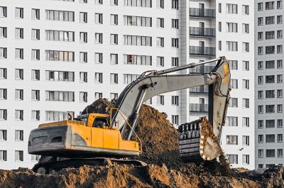 Экскаватор роет траншею под трубы